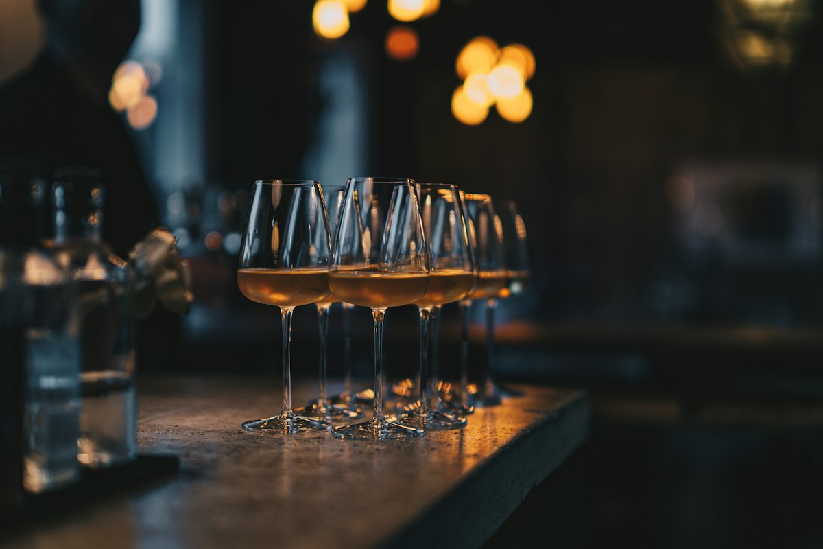 A row of poured white wines along the tasting bar