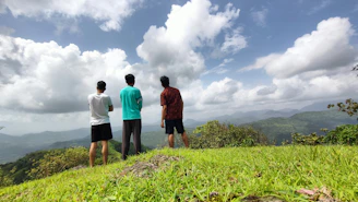 Three team members of Kaimoa Consulting standing together with the Big Island landscape in the background.