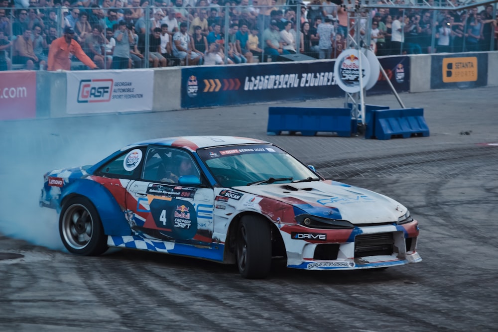 a race car on a track with a crowd watching