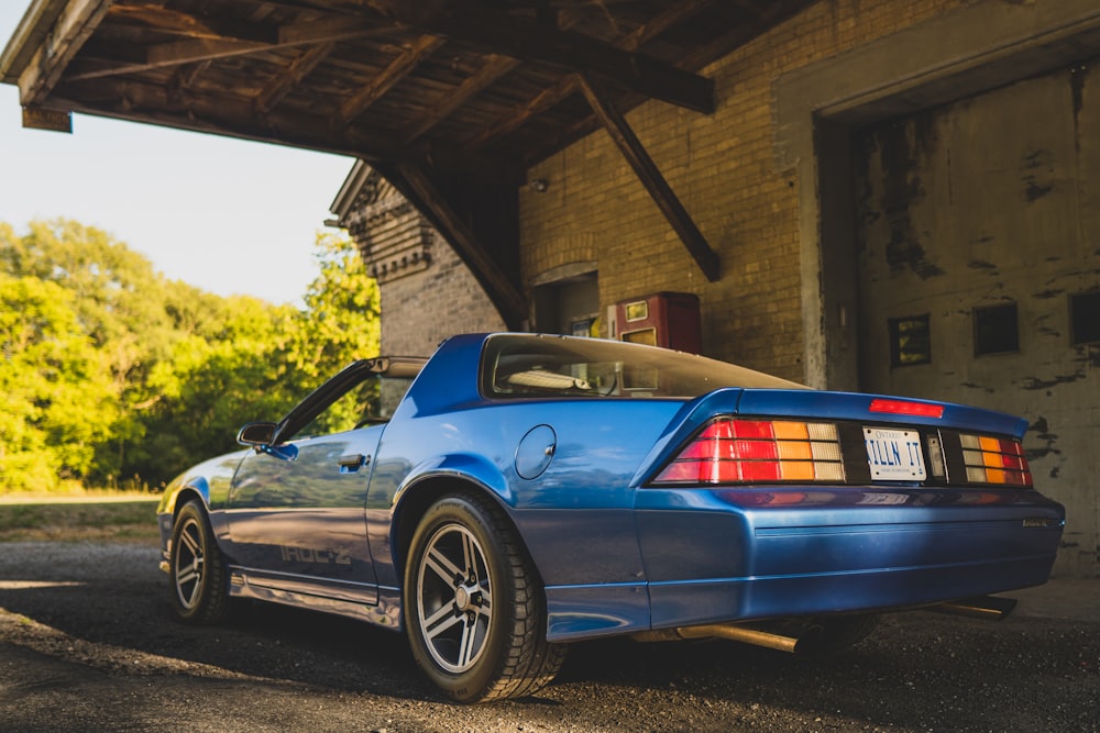 a blue sports car parked outside a building