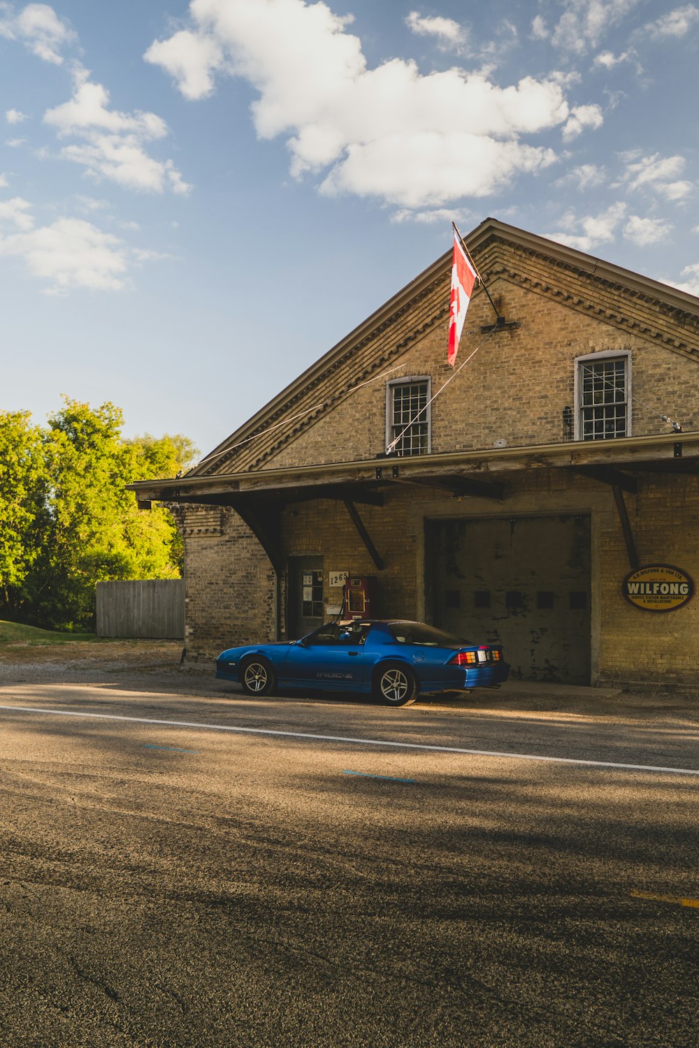 a car parked in front of a building with a flag on top