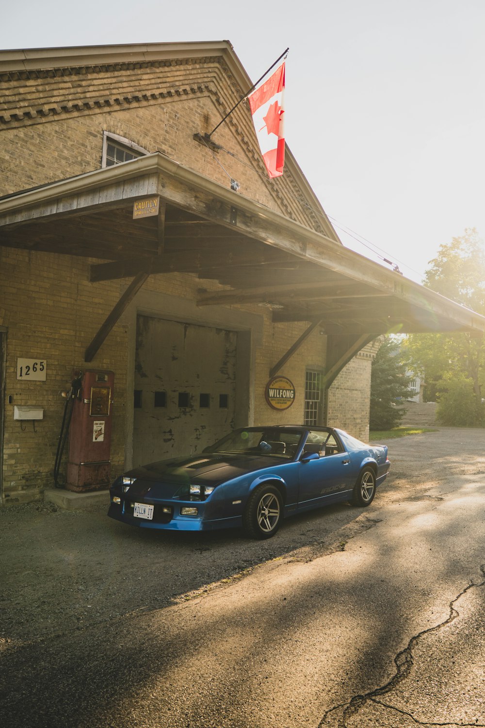 a car parked in front of a building with a flag on top