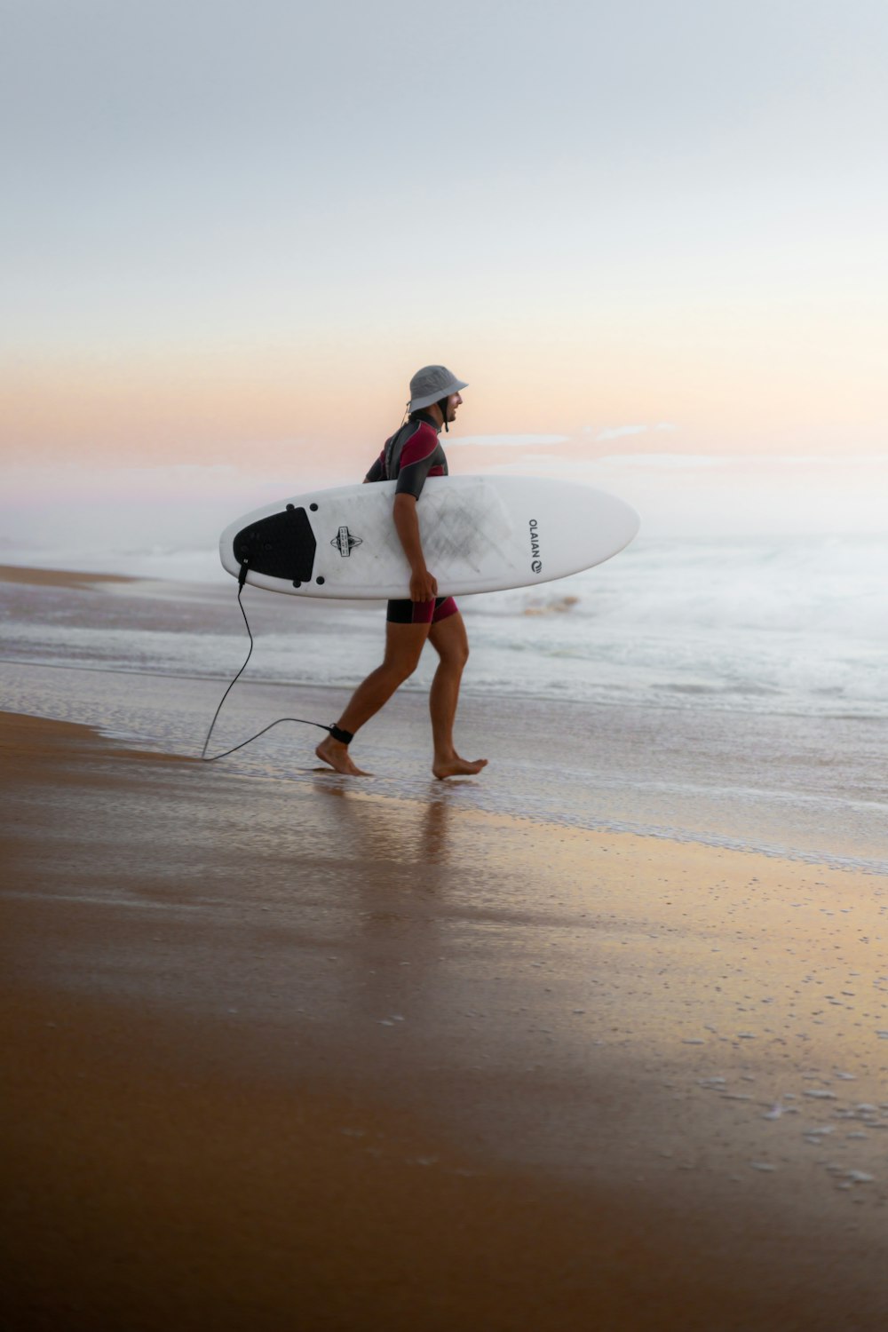 Un uomo che trasporta una tavola da surf su una spiaggia