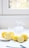 A bright kitchen scene with a bowl of fresh lemons and a jar of fermented lemons.
