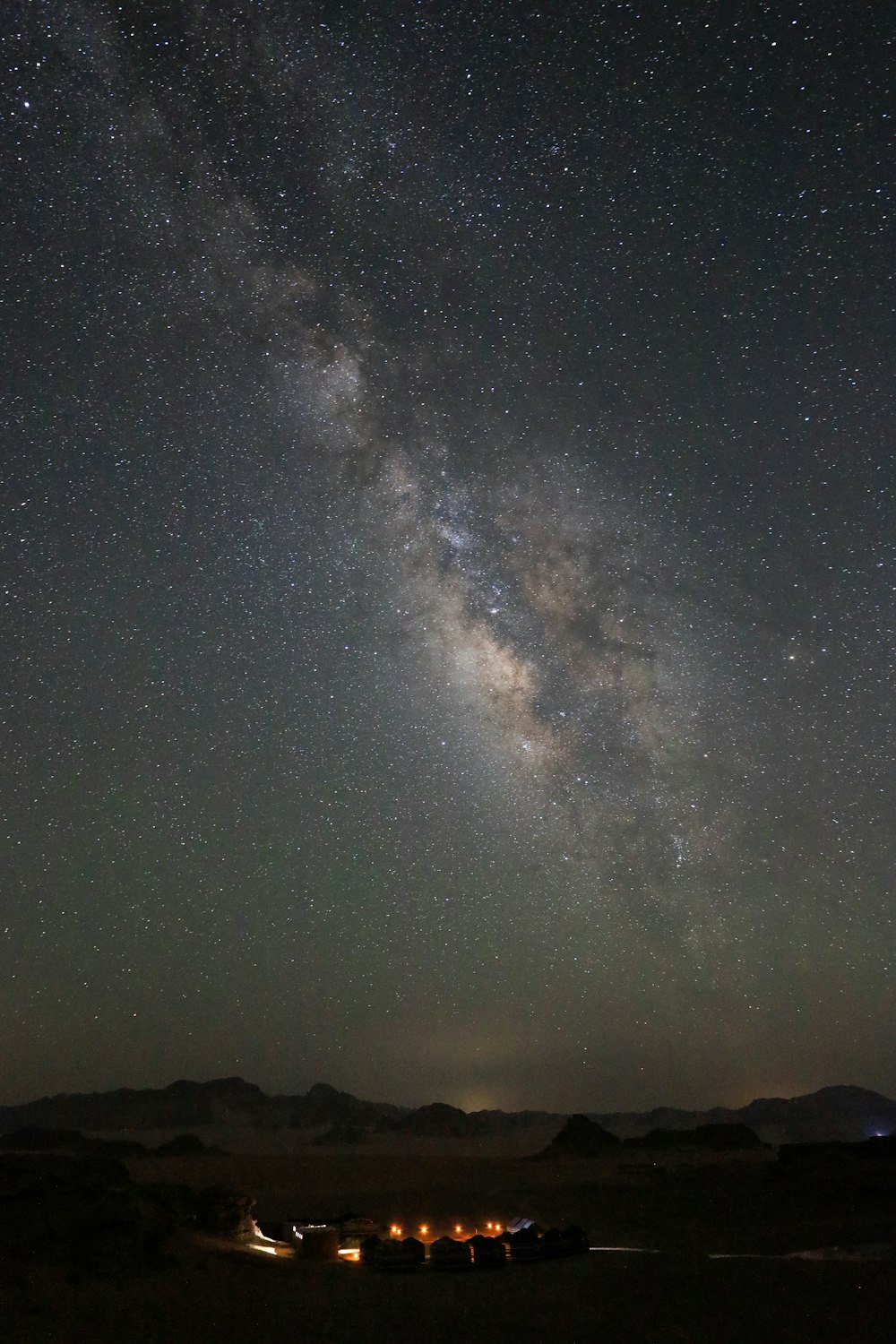 Un ciel nocturne avec des étoiles et une maison et un lac