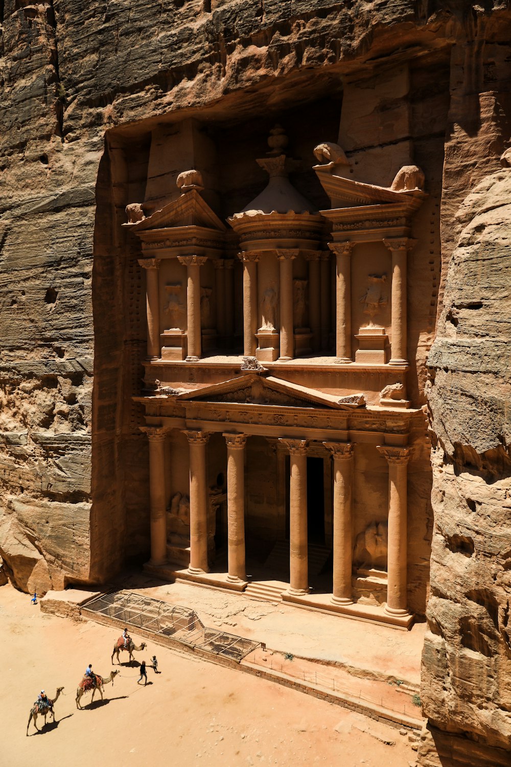 Petra con pilares y gente caminando alrededor