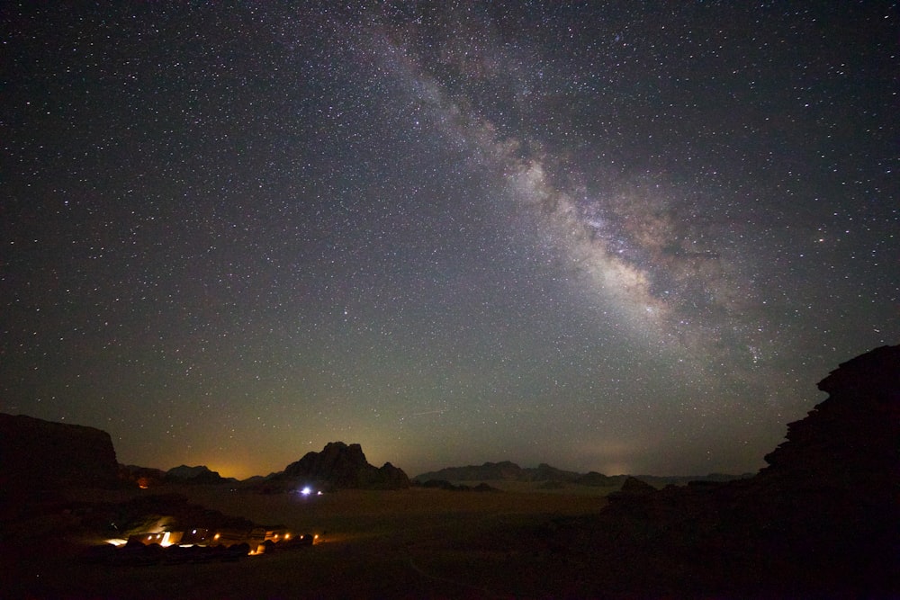 a night sky with stars and a mountain range