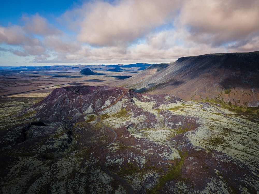 a landscape with hills and a body of water in the distance