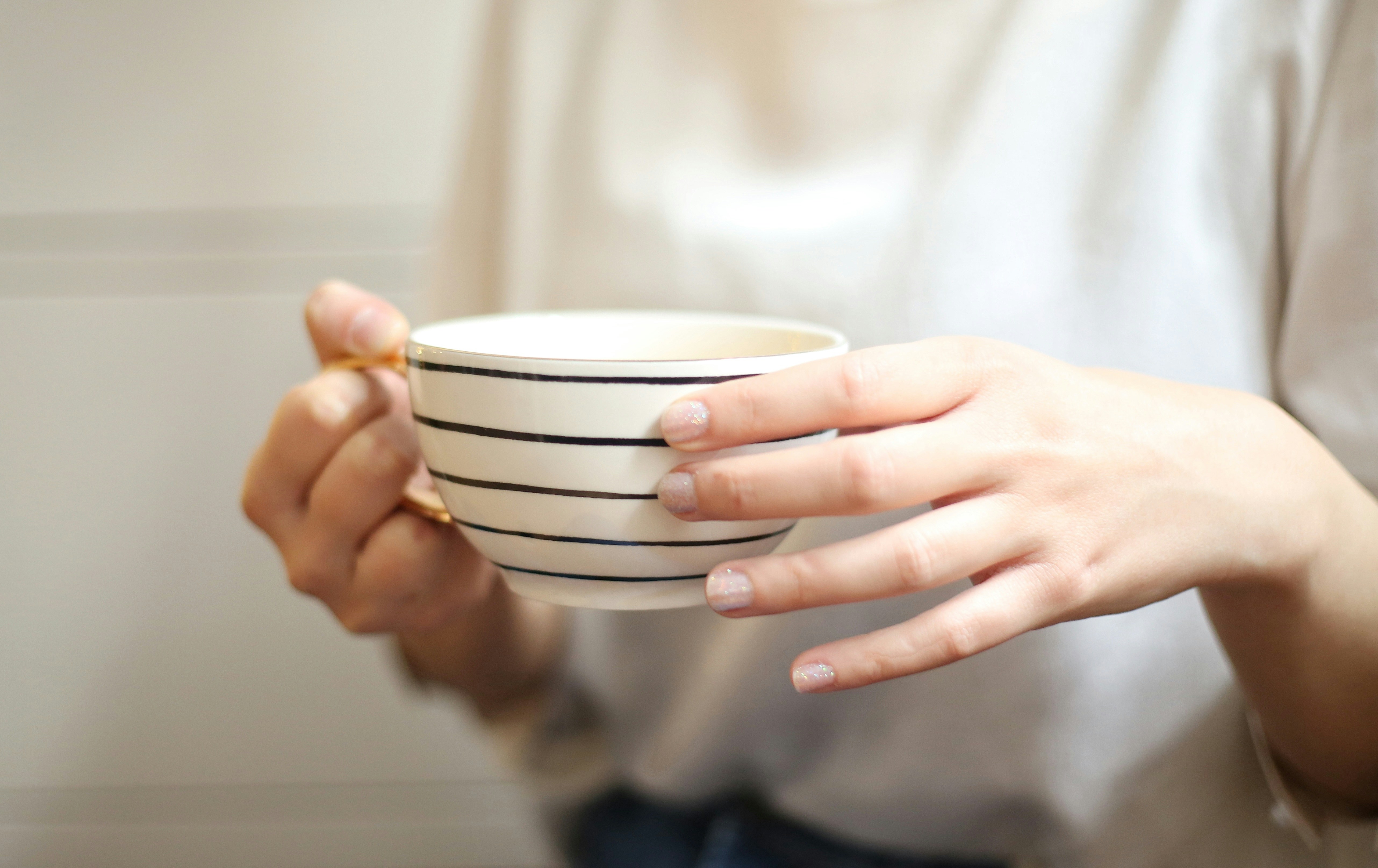 10 Small Habits That Can Make Your Mornings Less Stressful – a person holding a cup