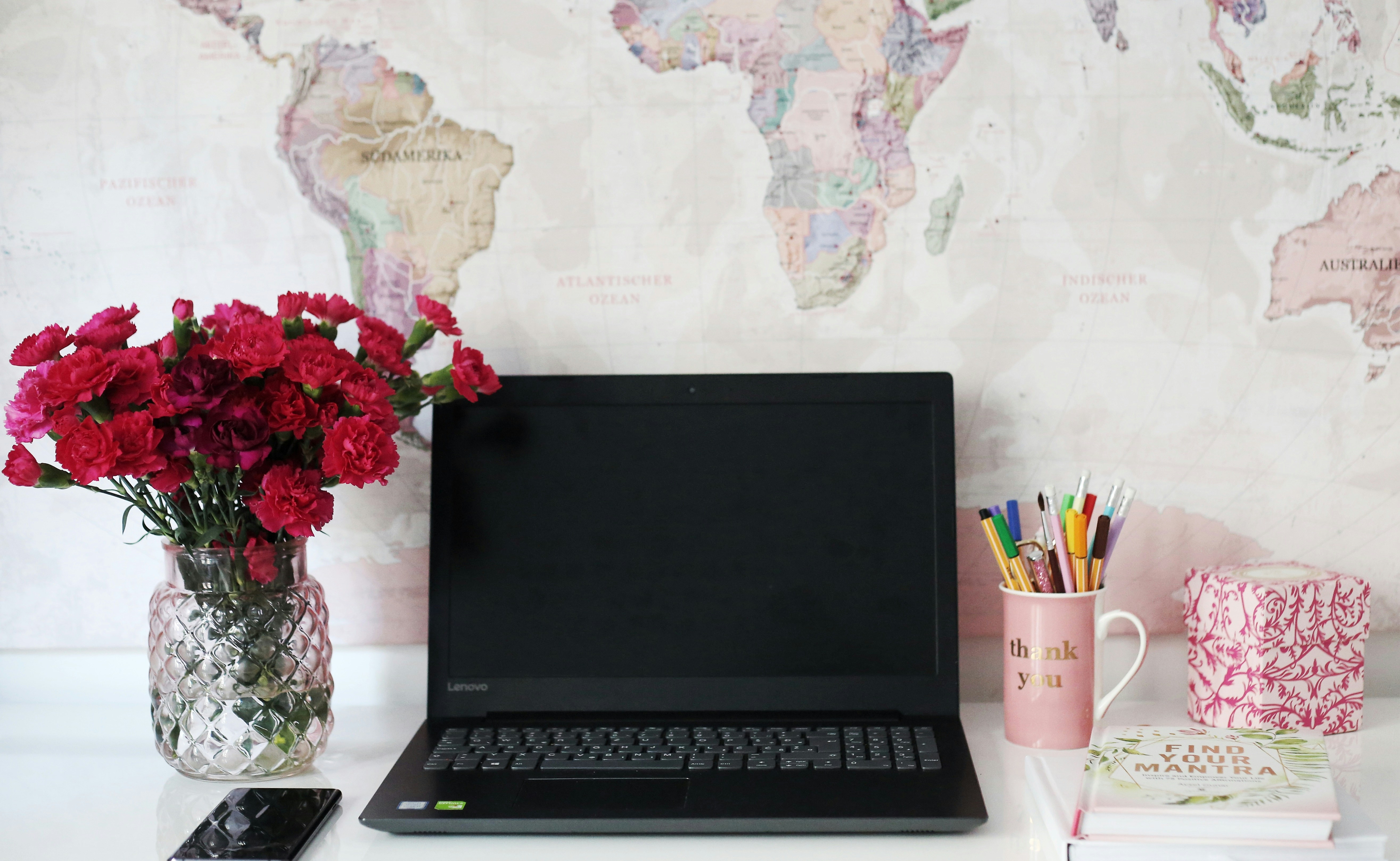 A classic, old-world map is spread out on a clean, modern desk next to a sleek, open laptop, symbolizing the intersection of traditional business principles and modern digital strategy.