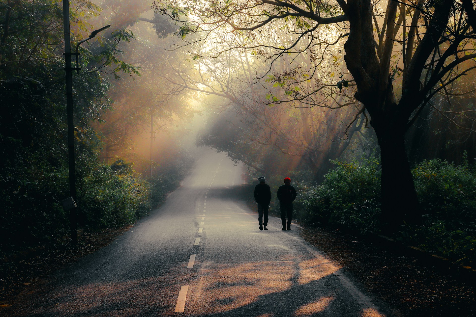 two people walking on a road