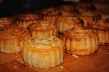 Assortment of golden, flaky pastries arranged on a rustic wooden board.