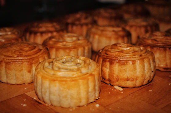 Assortment of golden, flaky pastries arranged on a rustic wooden board.