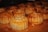 An array of golden-brown pastries arranged closely together on a wooden surface. Each pastry has a distinctive spiral pattern on the top, giving them an artisanal appearance.