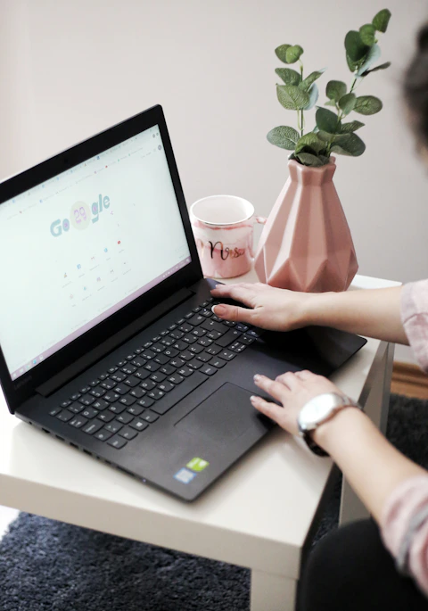 a person holding a cup and a laptop