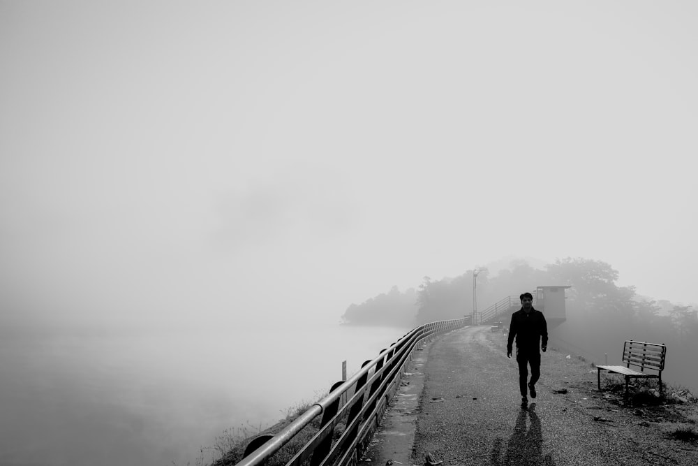 a man walking on a path in the fog