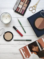 A flat lay of clean makeup products in earthy tones arranged on a linen cloth.