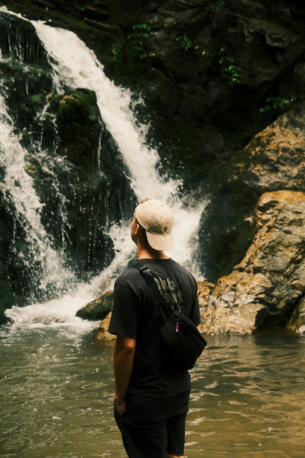 Un hombre parado frente a una cascada