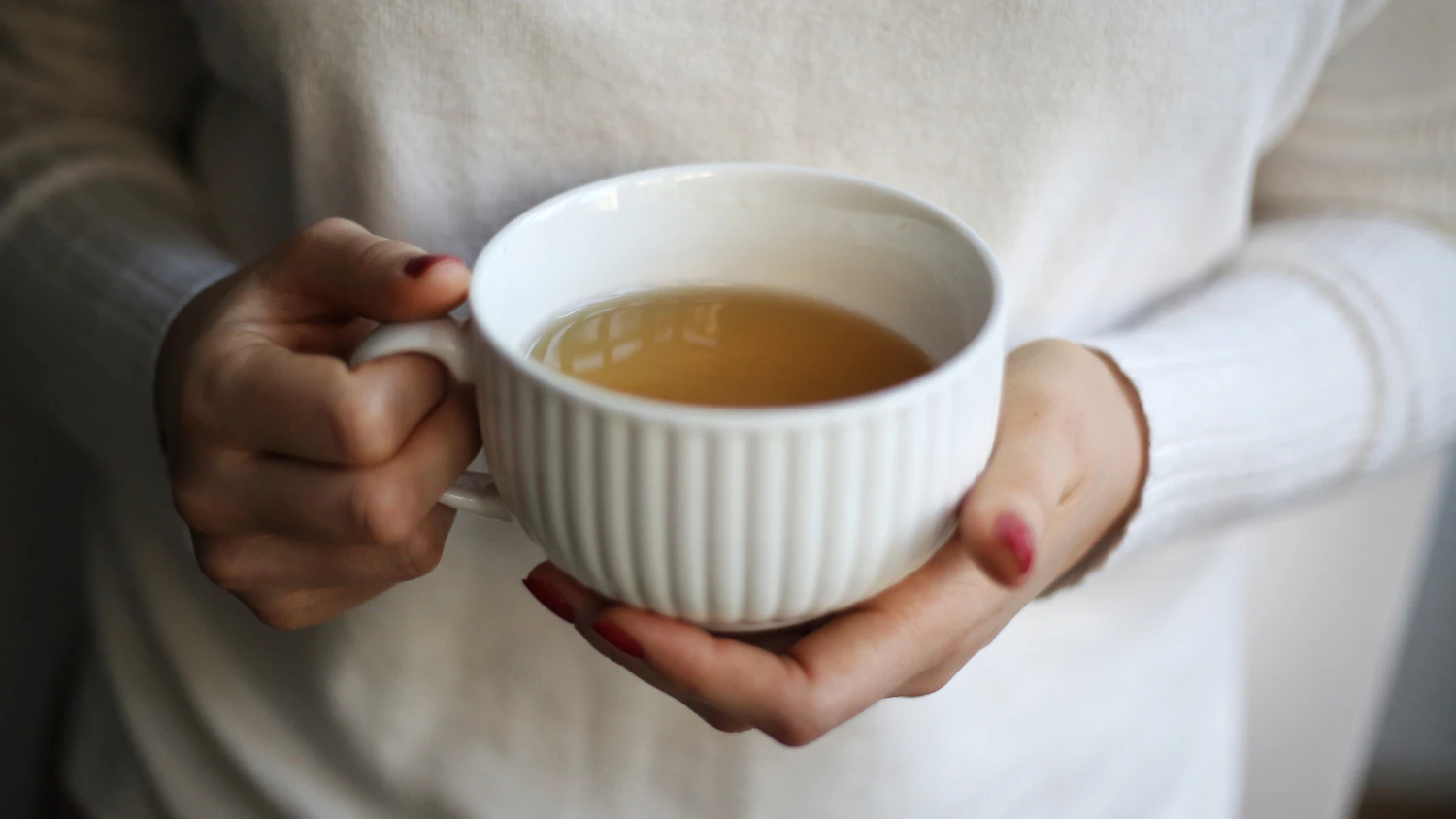 Hände halten eine Tasse Tee als Symbol für eine einfache Ersatzhandlung bei Rauchverlangen
