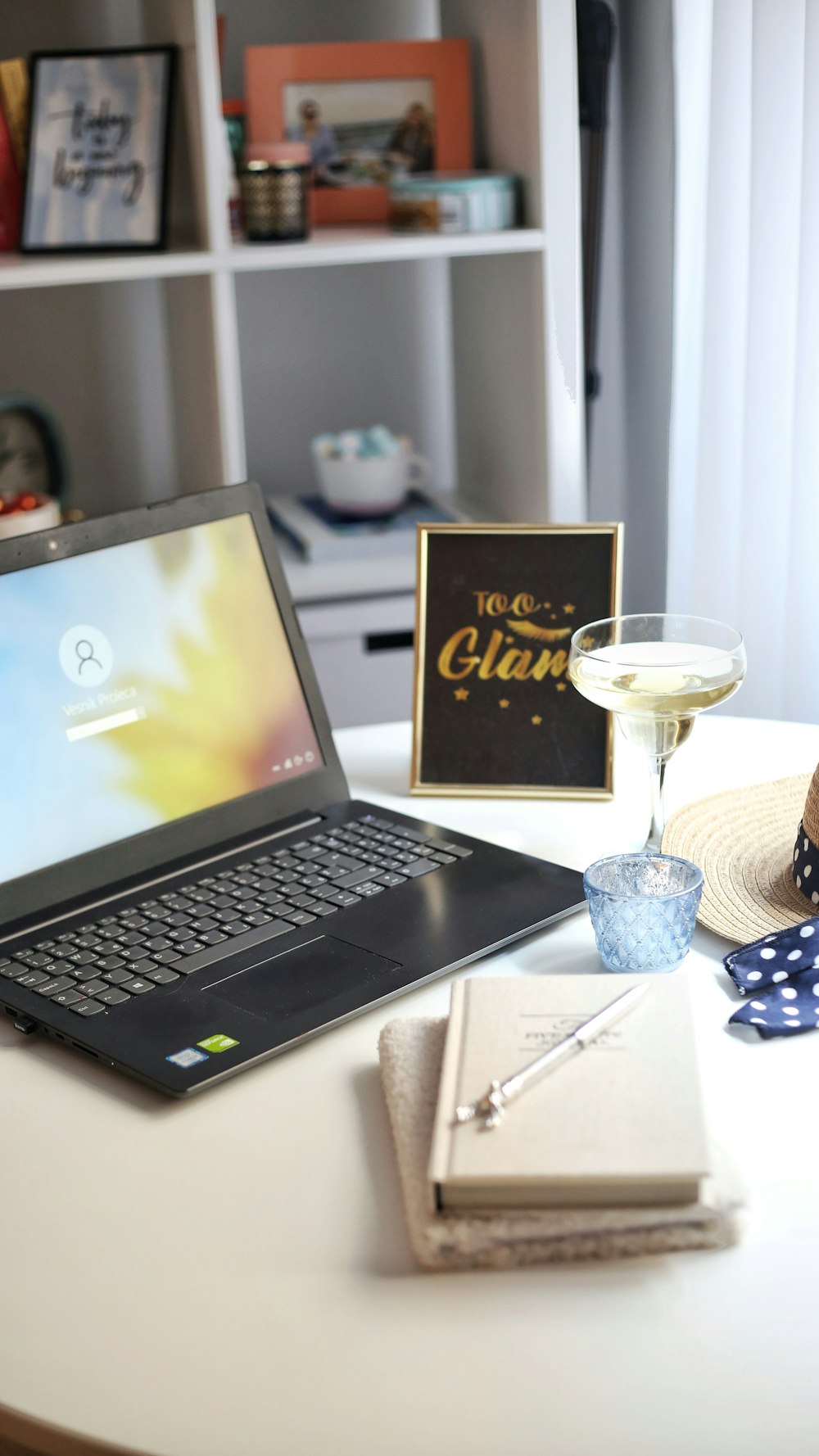 a laptop and a glass of wine on a table