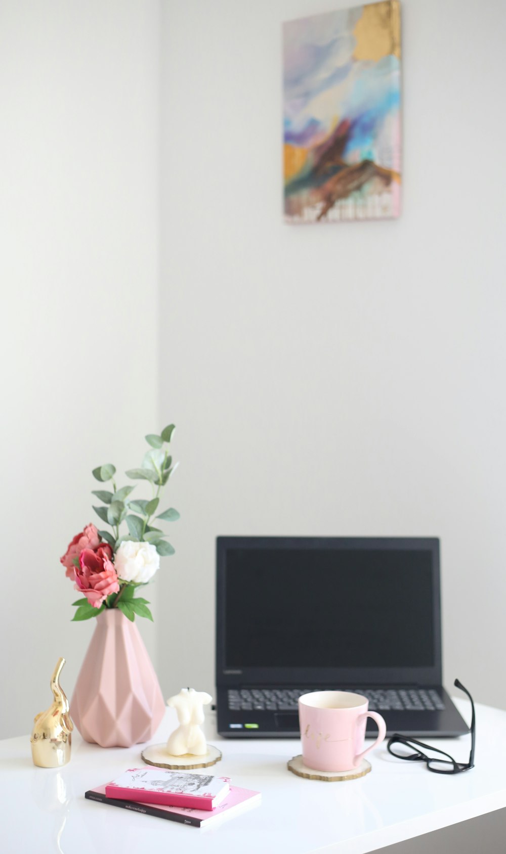 un computer portatile e un vaso di fiori