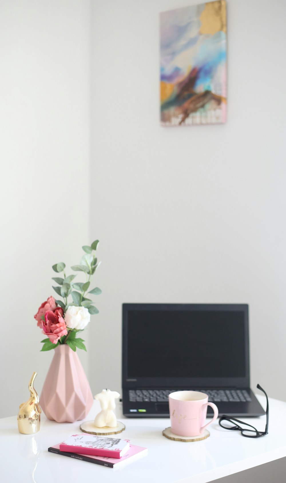 a laptop and a vase of flowers