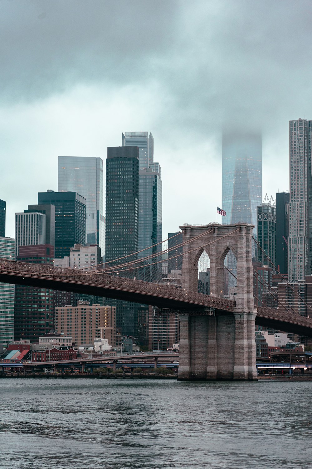 a bridge over a river with a city in the background