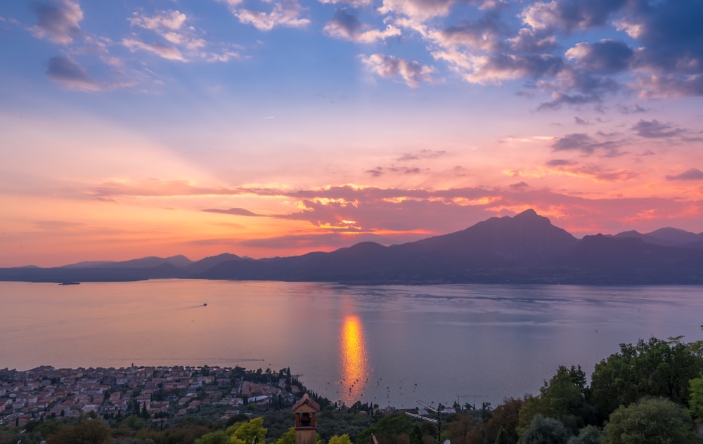 a body of water with a city and mountains in the background