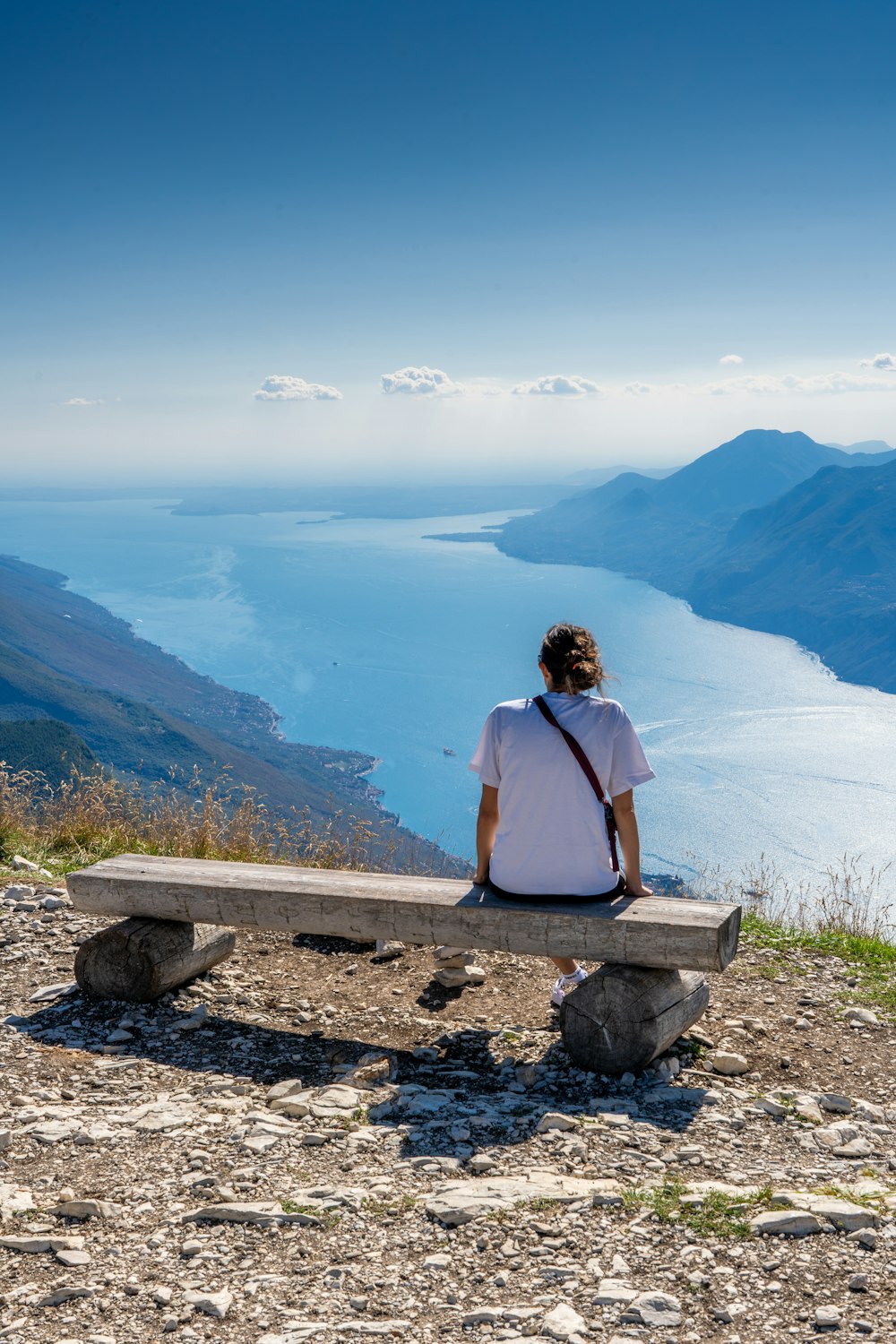 a person sitting on a bench overlooking a body of water