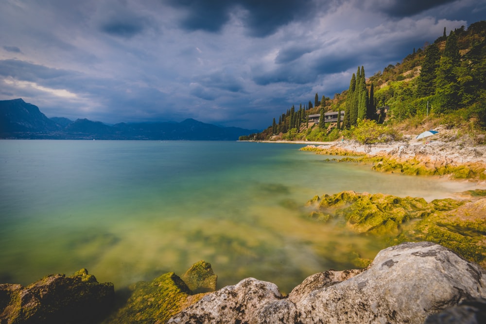 a rocky beach with a building on the shore