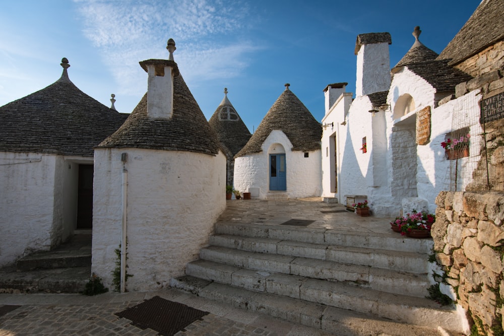 a stone building with a stone staircase with Alberobello in the background