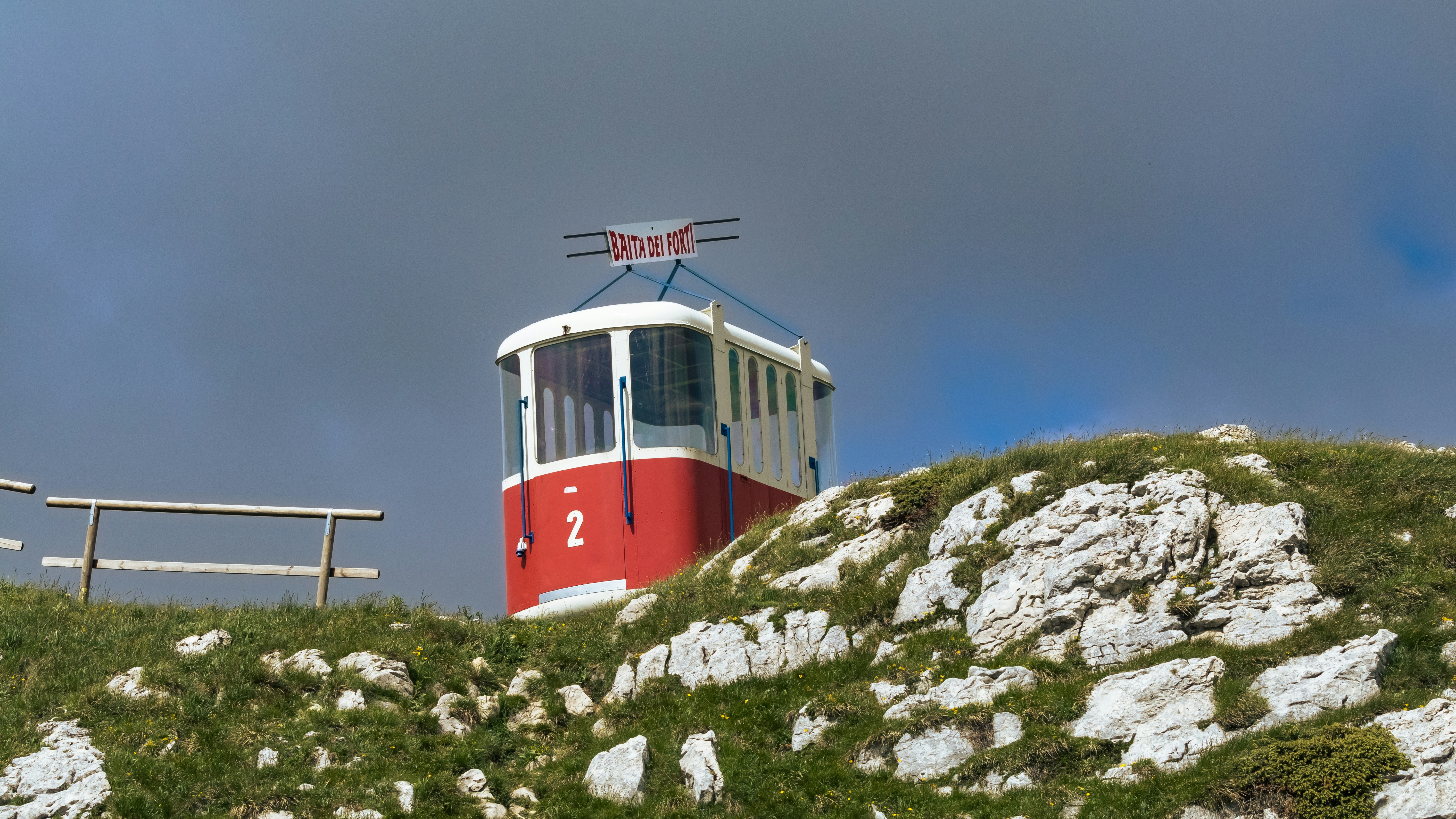 a red and white train on a rocky hill