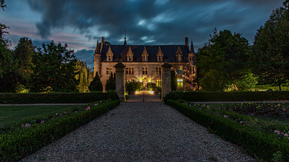 a stone path leading to a large building with a large garden in front