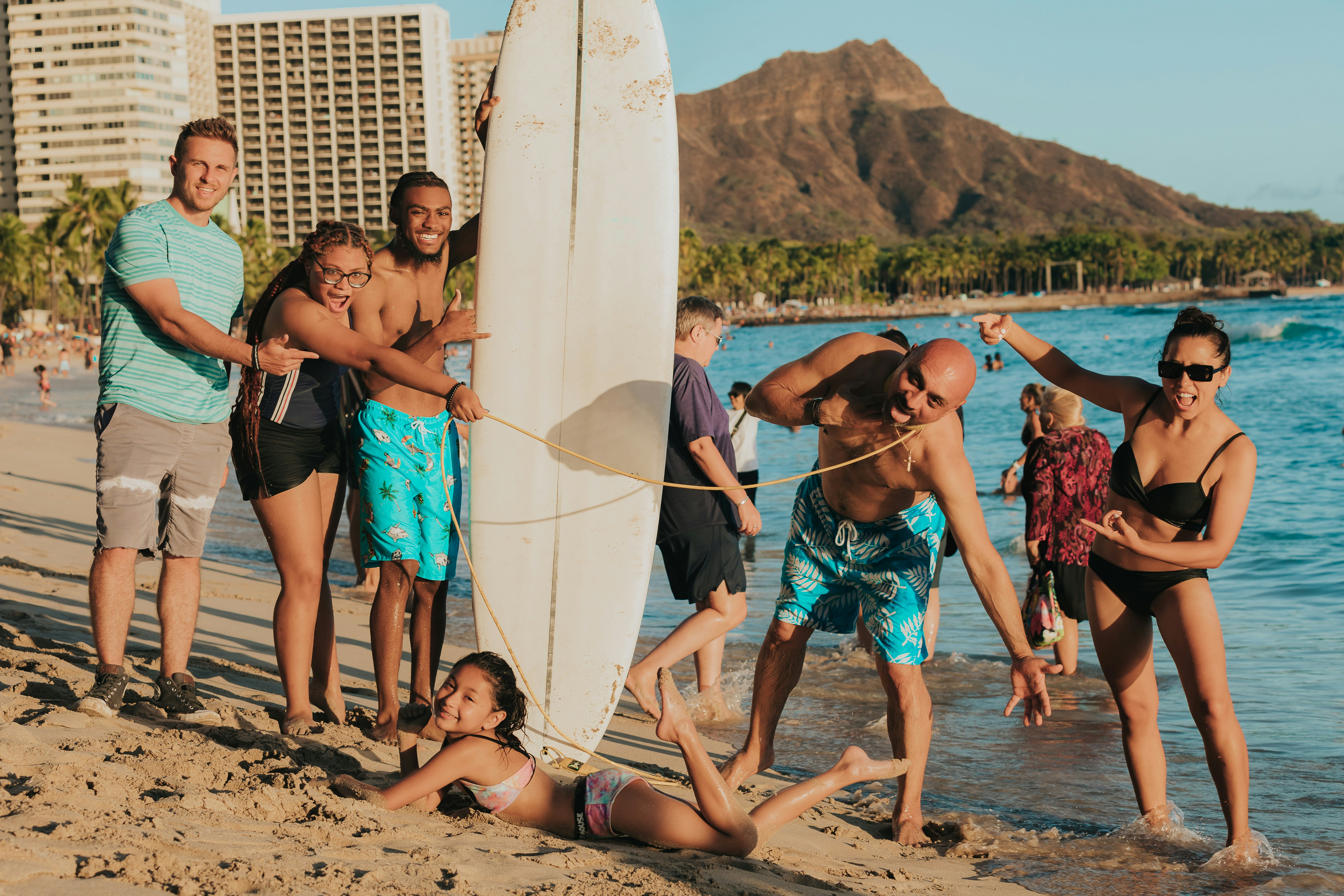 a group of people on a beach with a surfboard