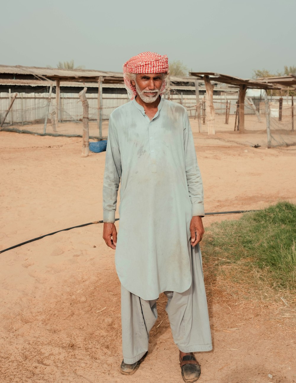 a man wearing a head scarf and a white dress