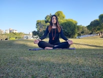 A person wearing an aimulet while practicing mindful meditation outdoors.