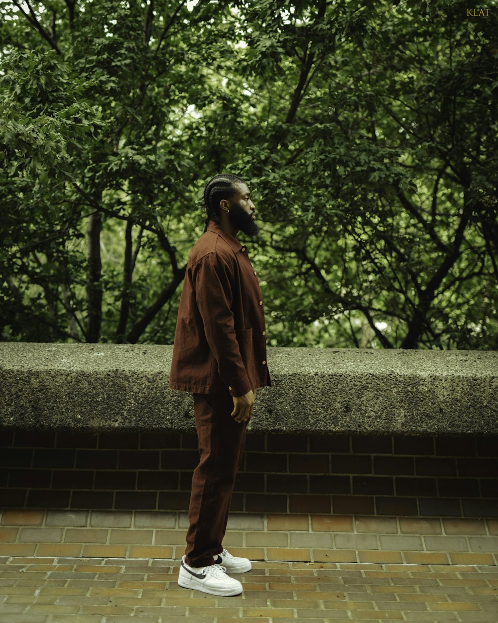 a man standing on a brick wall