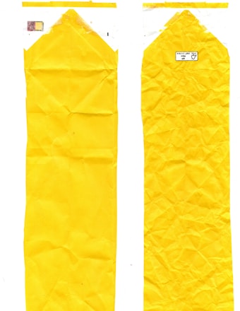 Two elongated, crumpled yellow plastic bags are displayed side by side. The left bag features a faint print of colors near the top, while the right one has a small label with text and recycling symbols.