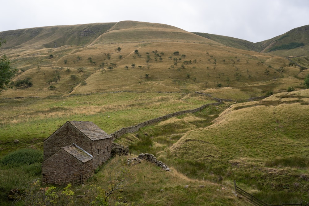 a stone building in a grassy field