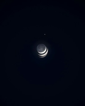 A dark night sky with a crescent moon captured in multiple phases, creating a layered effect. A small, bright star appears nearby, adding to the celestial theme.