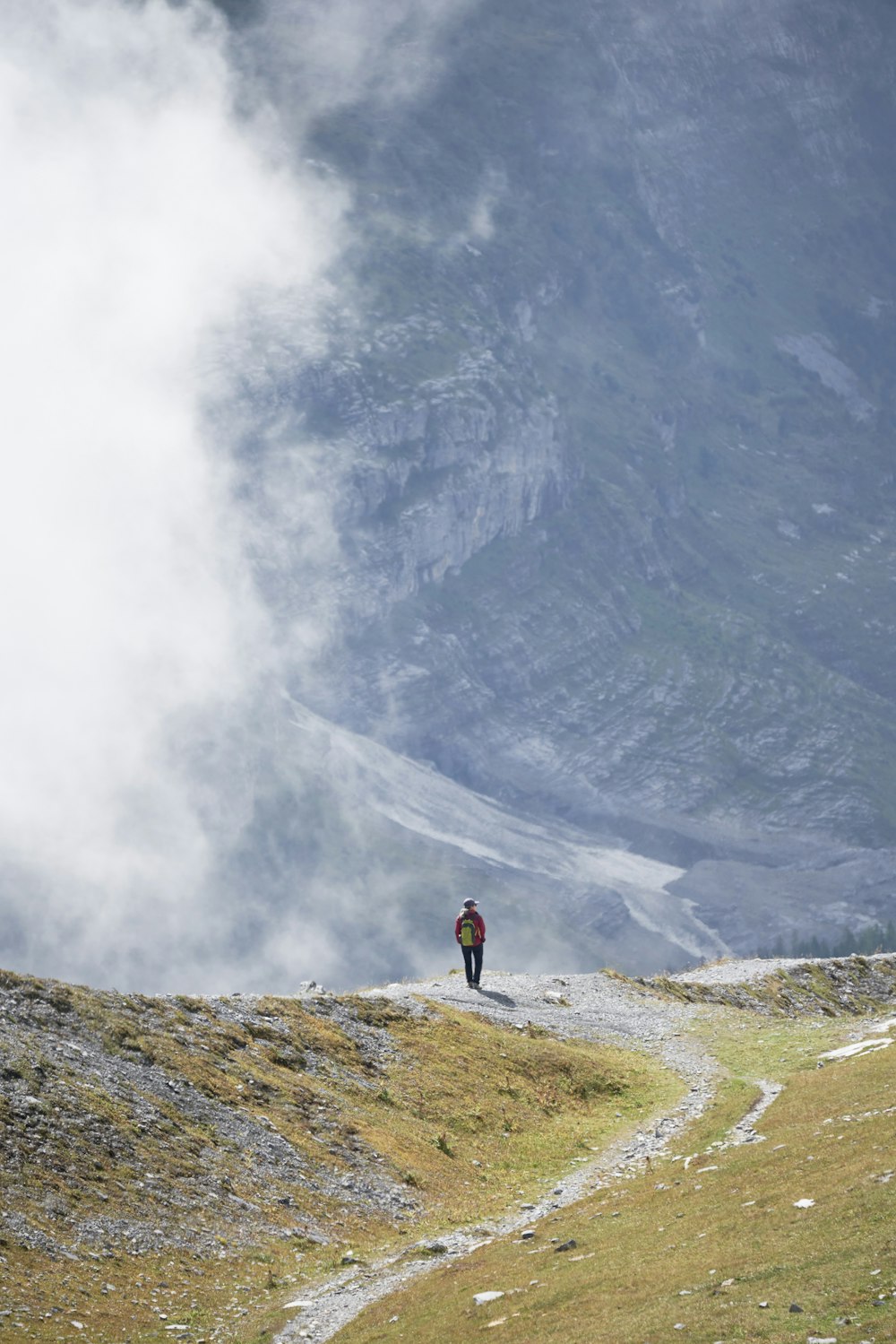 a person walking on a trail in a mountain