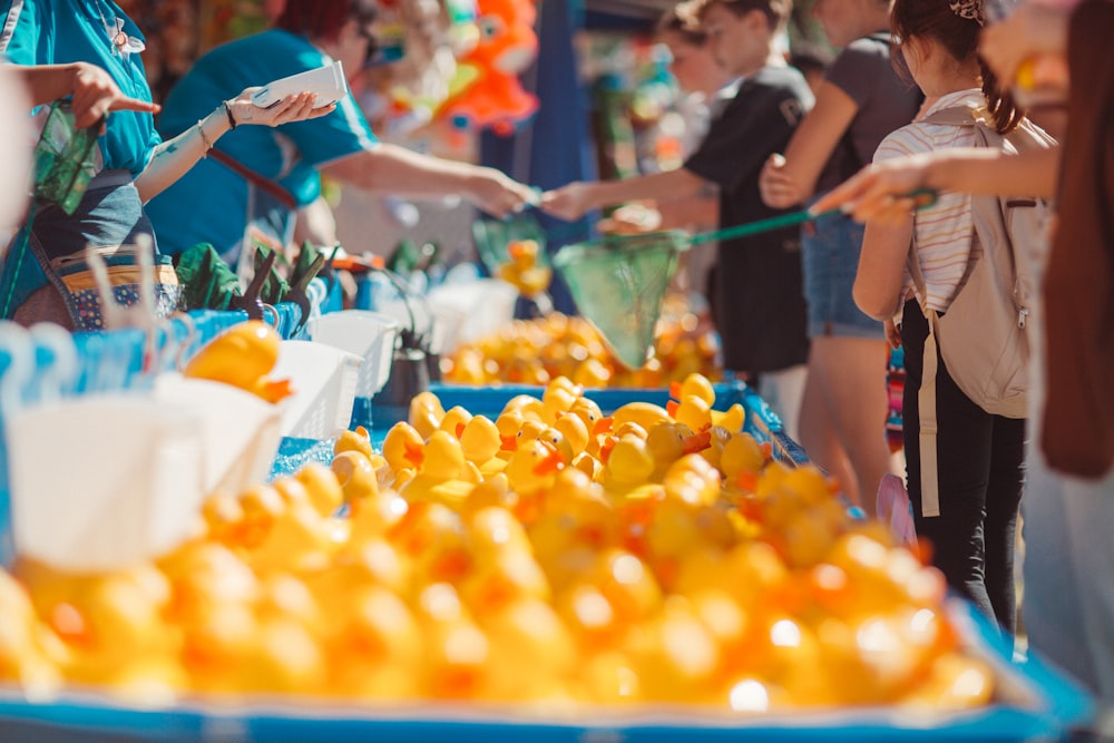 a group of people standing around a table full of oranges