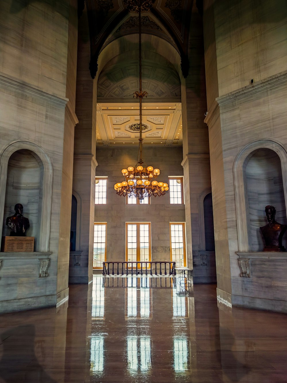 a large room with a chandelier and a large arched doorway