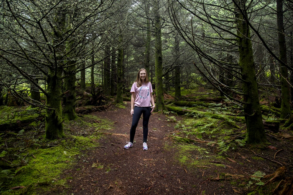 a person standing on a dirt path in a forest