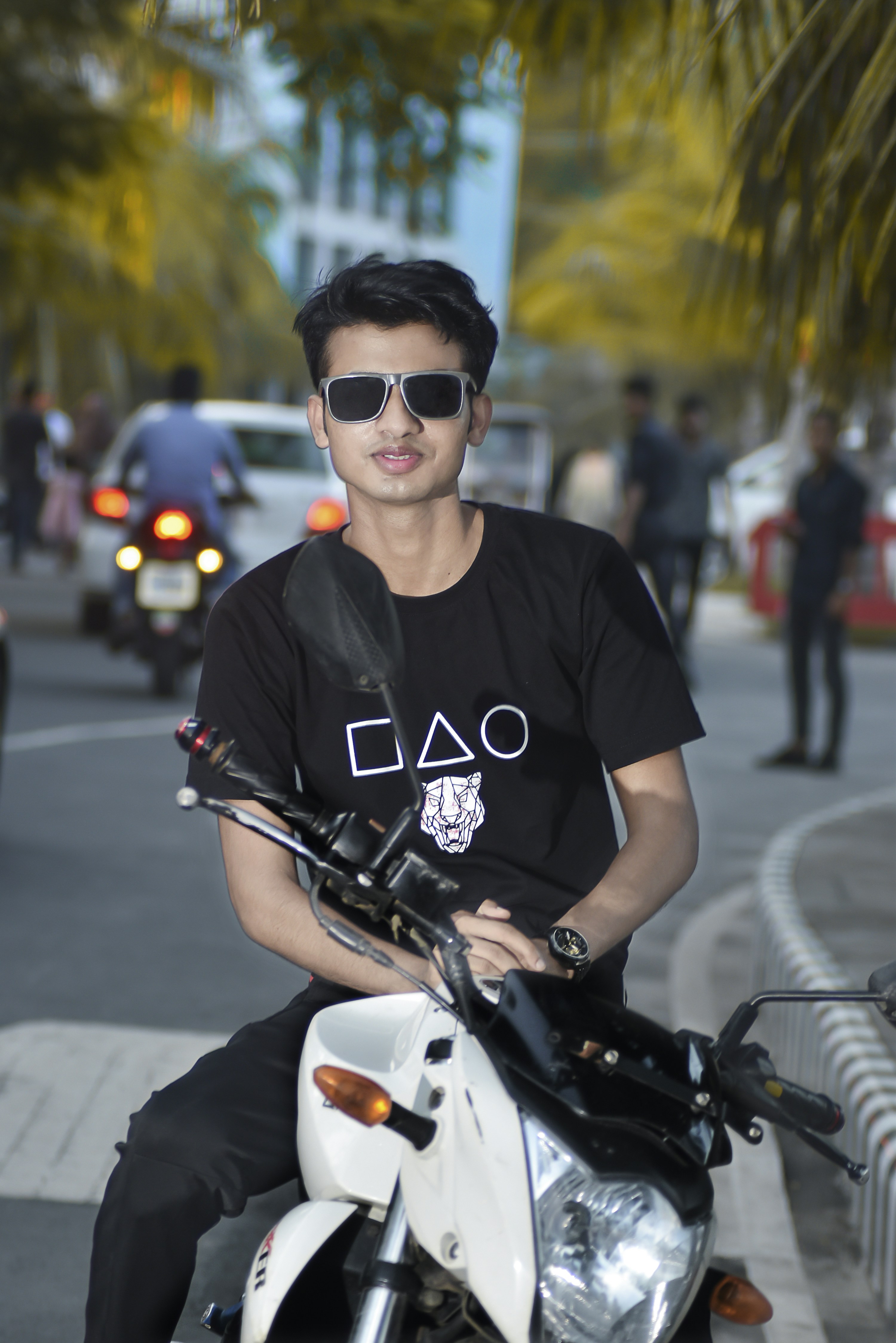 seseorang yang mengenakan kacamata hitam dan duduk di atas sepeda motor