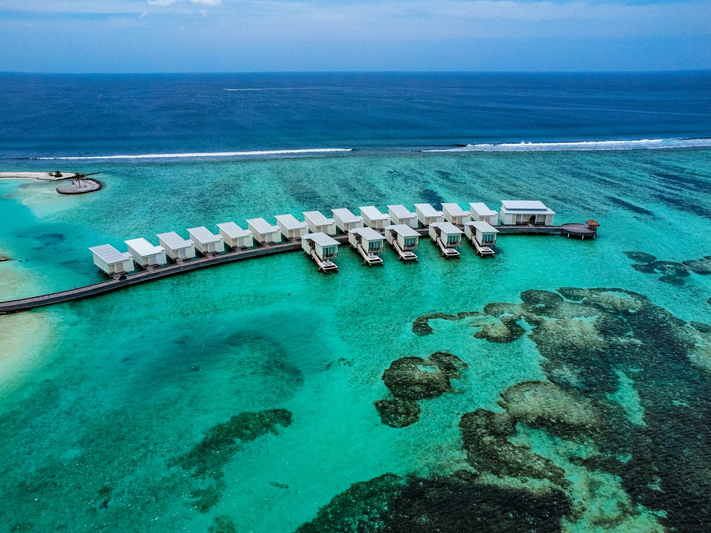 Maldives overwater bungalows stretching into turquoise lagoon