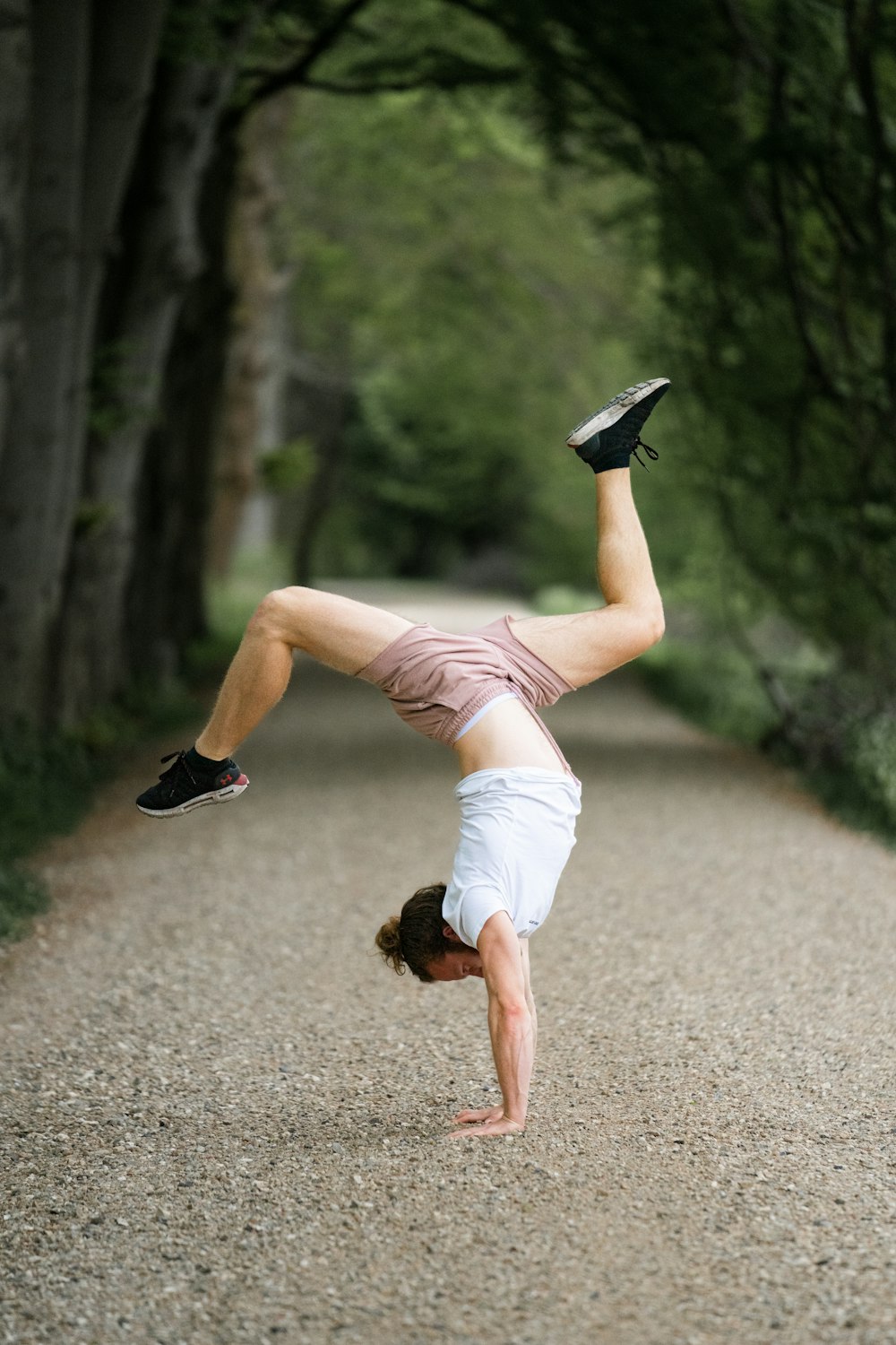 a person doing a handstand on a dirt path