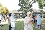 An outdoor scene with people enjoying portable tech devices.
