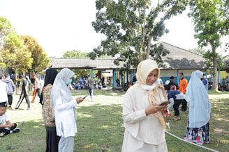 A group of diverse people engaging with their devices outdoors.
