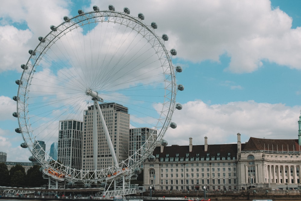 a ferris wheel and buildings with London Eye in the background